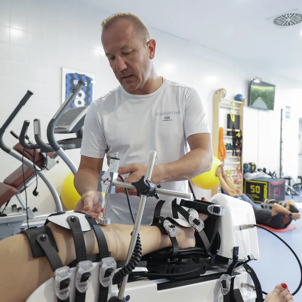 Physiotherapist adjusting a continuous passive motion device to assist a patient’s knee rehabilitation and enhance recovery after orthopaedic surgery in a sports clinic.