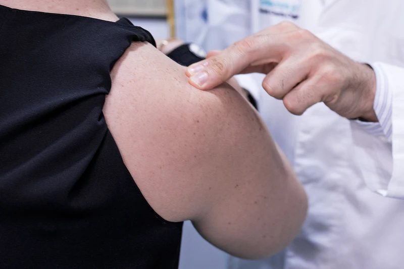 Doctor evaluating a patient’s shoulder to diagnose soft tissue or rotator cuff injuries.